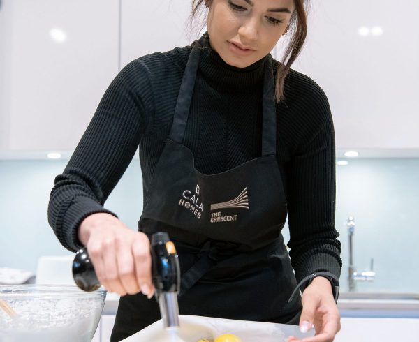 Property PR image of The Great British Bake Off finalist Ruby Bhogal baking in a kitchen at The Crescent by CALA Homes. Photoshoot organised by an Edinburgh PR agency, Holyrood PR.